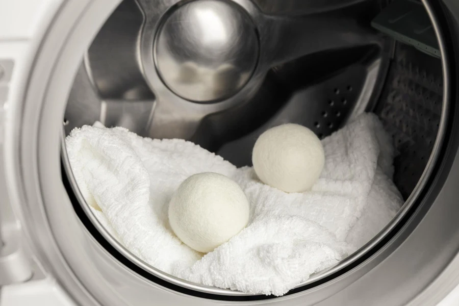 wool dryer balls and a towel in a washing machine