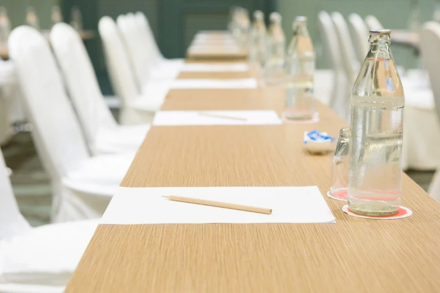 garrafa de água, copo sobre a mesa no fundo da sala de seminários