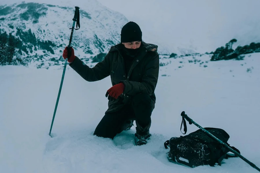 Hombre en cuclillas sobre suelo cubierto de nieve