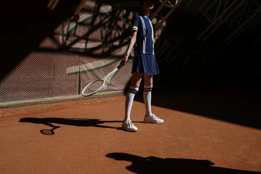 Una ragazza in abbigliamento sportivo blu che gioca a tennis