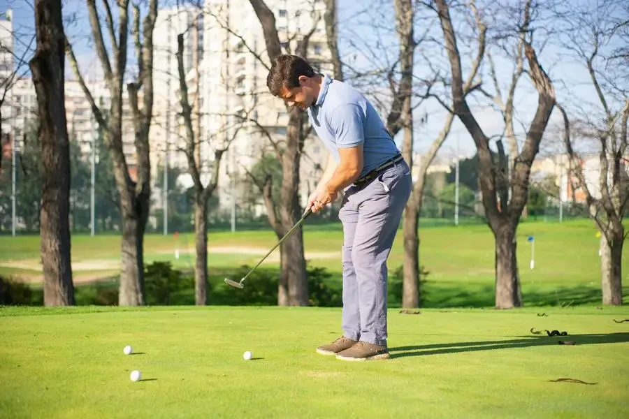 Un uomo in piedi sull'erba verde mentre gioca a golf di Kampus Production