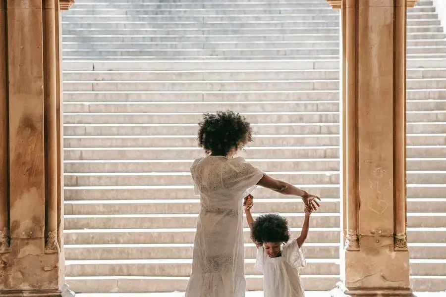 Una mujer bailando con su hija junto a un arco, de Barbara Olsen