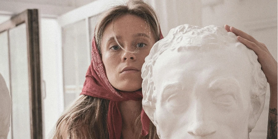 Une femme serrant une sculpture de buste de tête