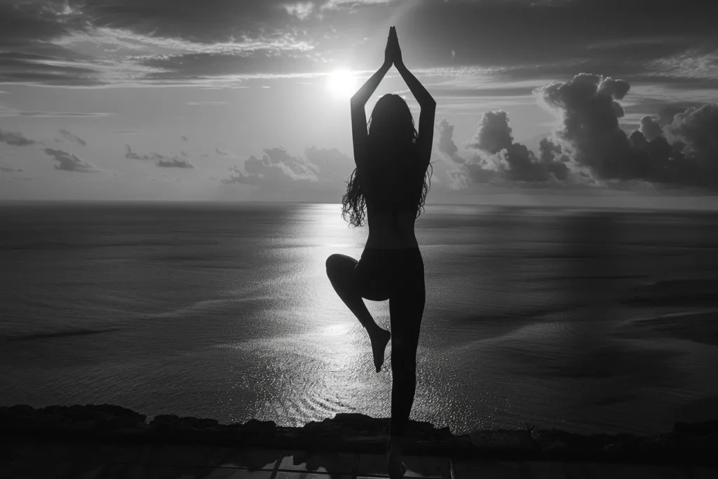Uma foto em preto e branco de uma mulher fazendo ioga em silhueta