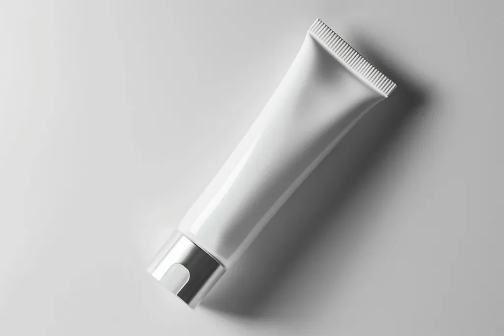 A tube of white cream with an opening at the top and bottom