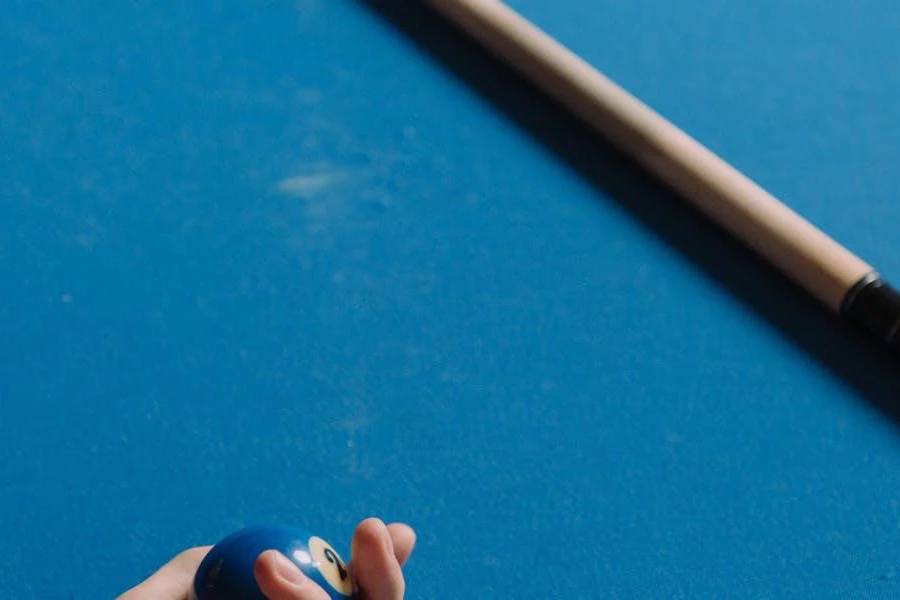 A white and black cue on a blue table