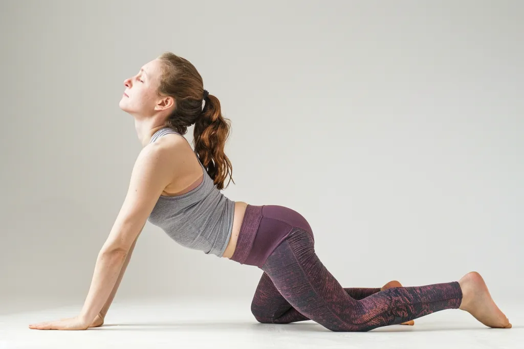 A woman in yoga attire is gracefully performing the cobra pose