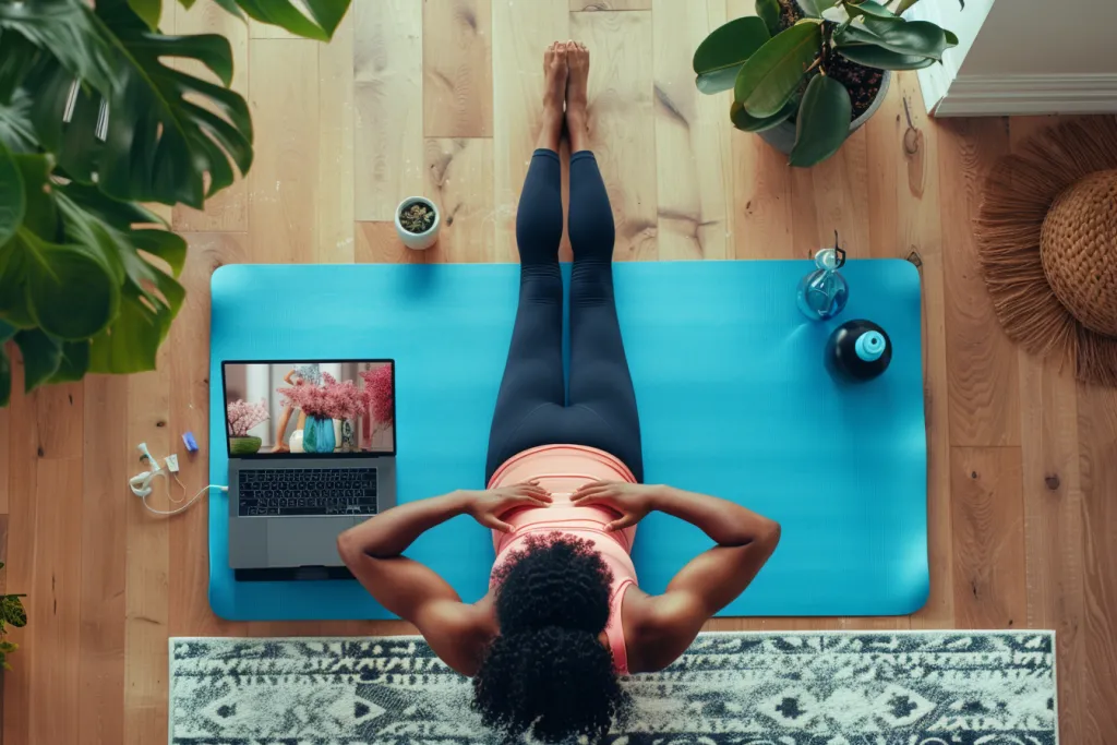 Uma mulher está deitada em seu tapete de ioga assistindo a um vídeo de treino online