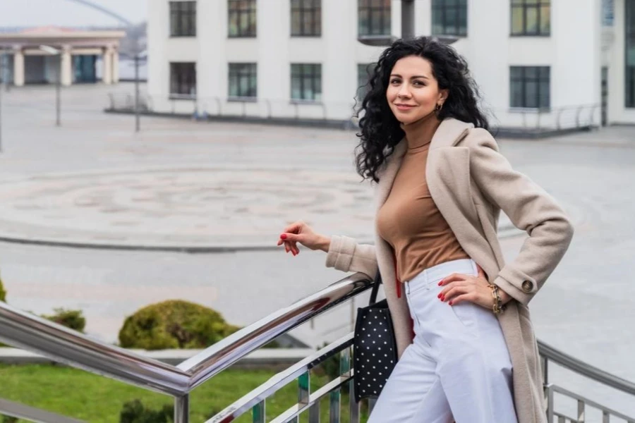 Mulher bonita aplicando camadas de vestuário