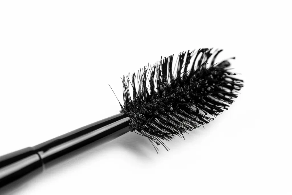 Black mascara brush with long black voluminous lashes isolated