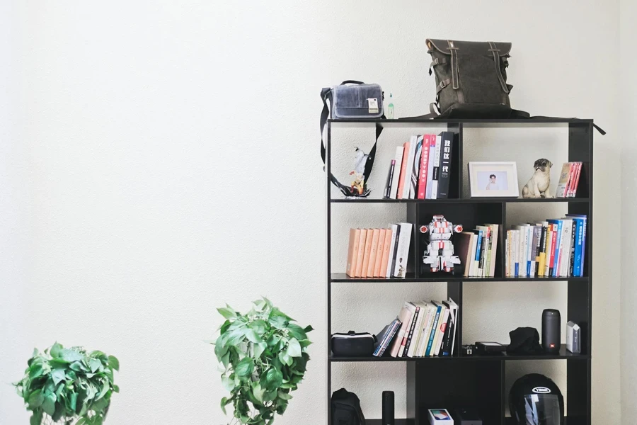 Buku dan Speaker di Rak Kayu Hitam