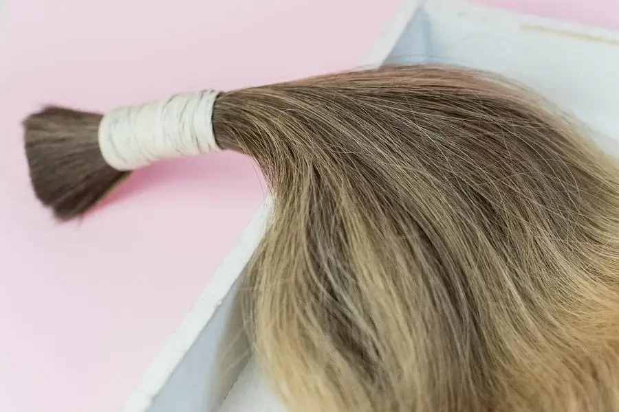 Bundle of Hair Extension on Pink Background by Alina Skazka