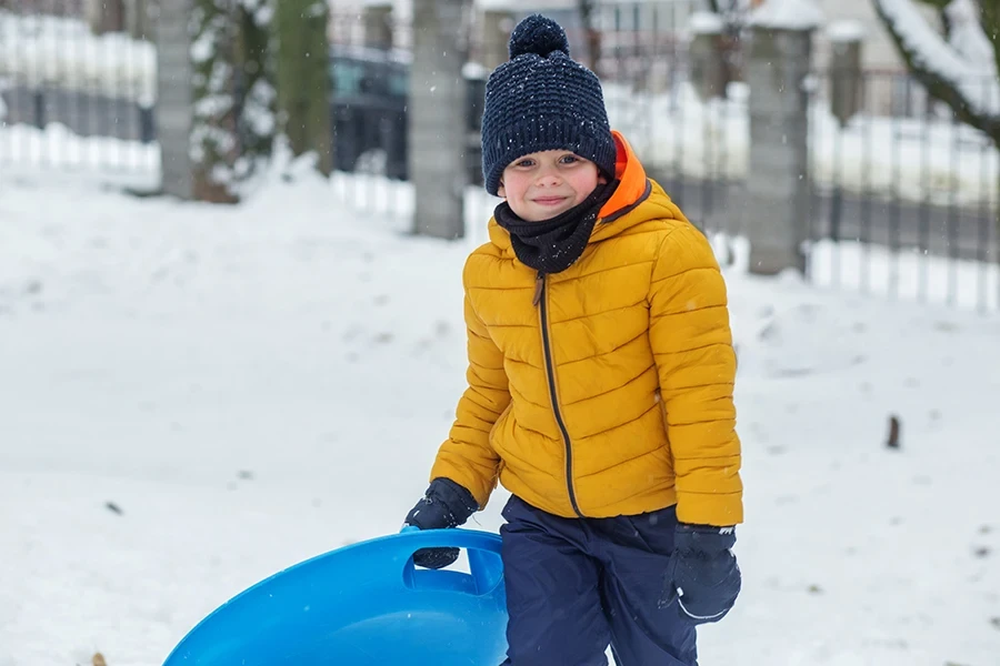 Criança menino andando na placa de neve