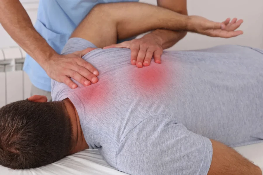Trattamento chiropratico. Massaggio Shiatsu, punti trigger del mal di schiena. Fisioterapia per paziente di sesso maschile, recupero da infortuni sportivi