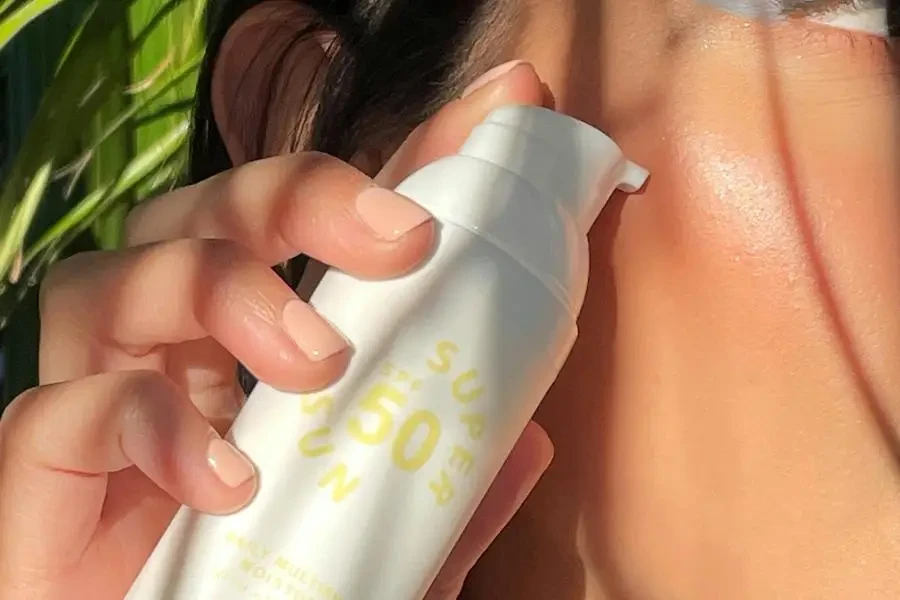 Close-up of Woman Holding Sunscreen in a Bottle with a Pump by Sunny Skin