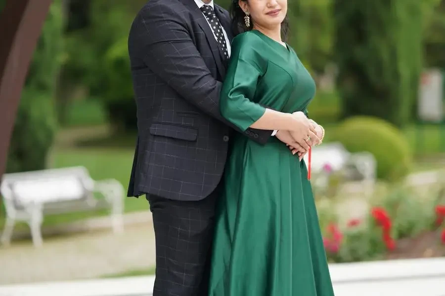 Casal em pé no chão de ladrilhos do jardim usando vestido formal de Samir Aliyev