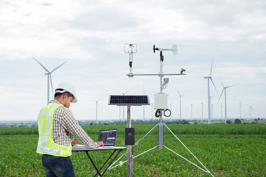 Engenheiro usando tablet coleta dados com instrumento meteorológico para medir a velocidade do vento