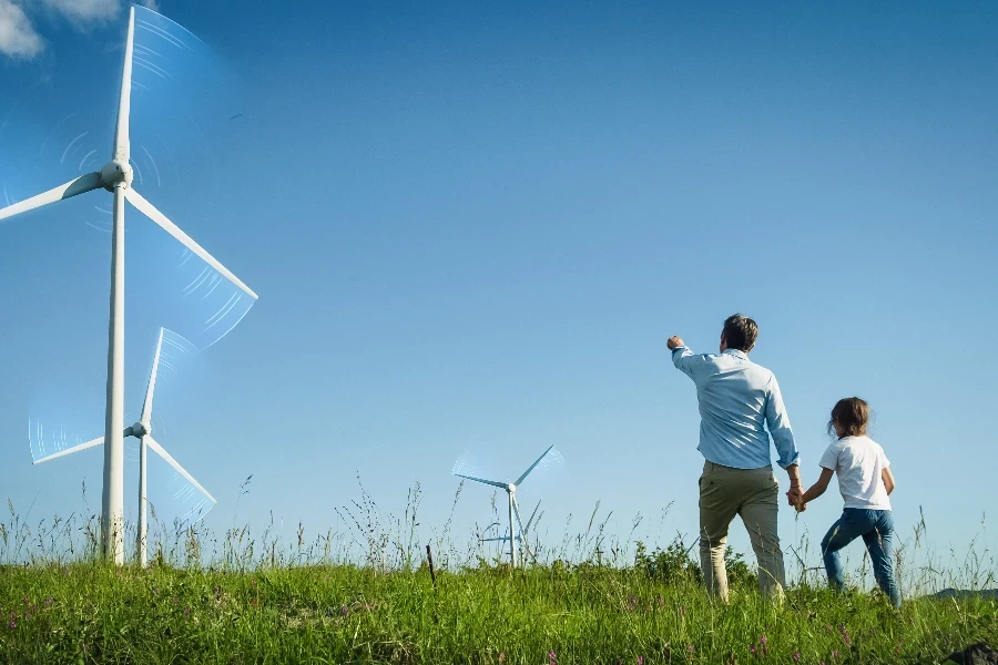 Vater und Tochter gehen durch modernen Windpark