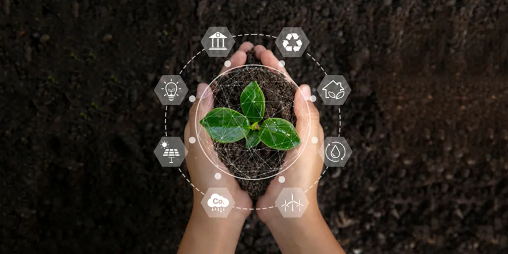 Hand holding a sapling with environment icons