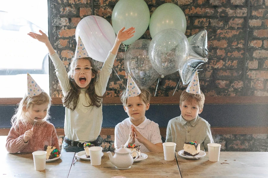 Glückliche Kinder auf einer Party sitzend auf einem Stuhl