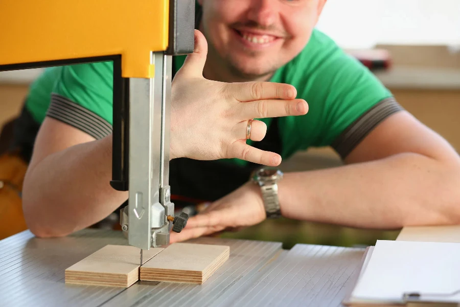 Happy smiling worker wearing yellow hard hat shows four fingers portrait