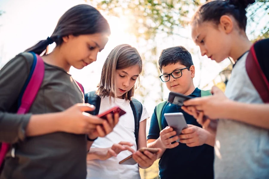 Niños jugando videojuegos en teléfonos inteligentes