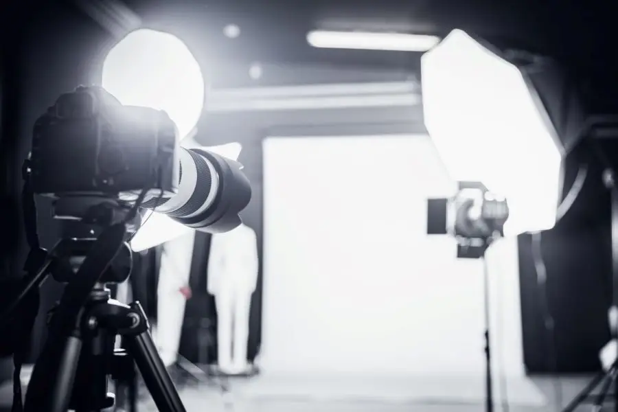 Gran estudio fotográfico con equipo de iluminación profesional y cámara.