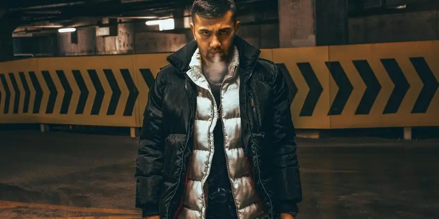 Man Wearing Puffer Jackets Blowing Smoke from a Cigarette by Volkan Erdek