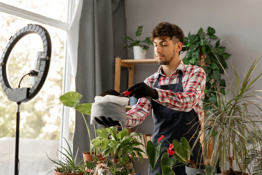 Man filming himself repotting a plant