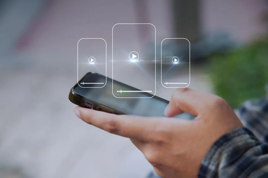 Manos de hombre sosteniendo el teléfono móvil y seleccionando un video