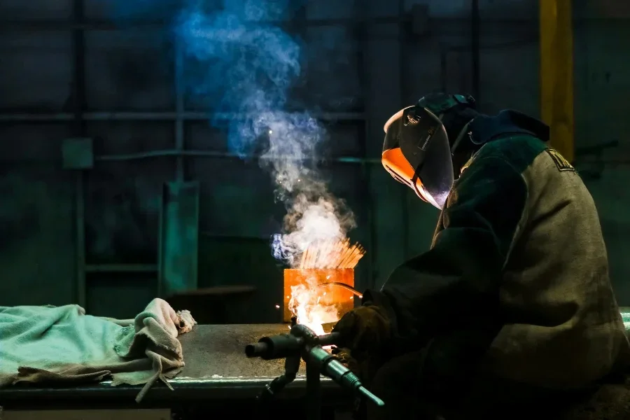 Mann In Schwarzer Jacke Und Orangefarbenem Helm Sitzt Auf Stuhl