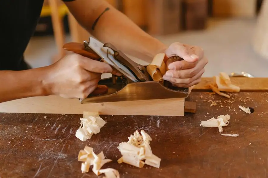 Man planing wooden plank with manual tool by Ono Kosuki