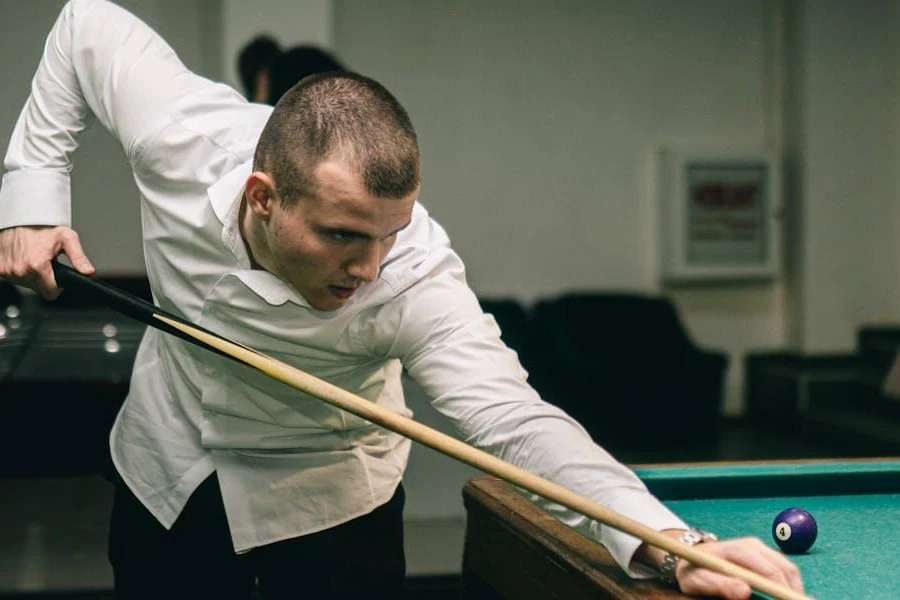 Man using cue on a greem pool table