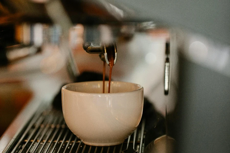 Modern coffee machine preparing double shot espresso pouring in white ceramic cup