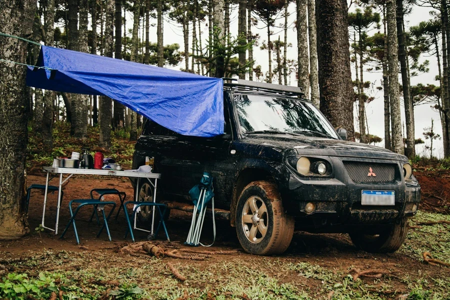 Coche todoterreno parado junto a un lugar de picnic en el bosque