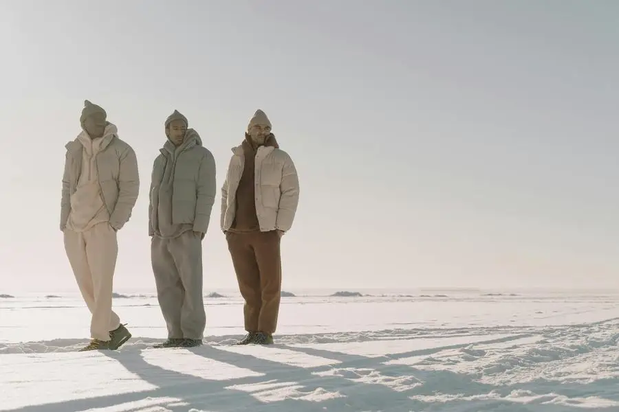 Personas con ropa de invierno de pie en un campo cubierto de nieve, por Cottonbro Studio