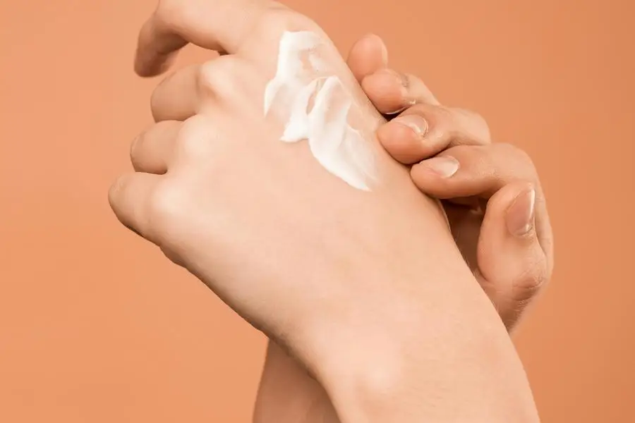 Person Applying Hand Cream by Shiny Diamond