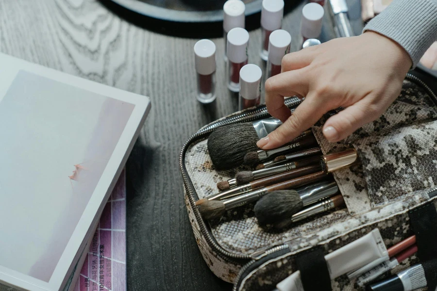 Personne tenant un ensemble de pinceaux de maquillage blancs et marron