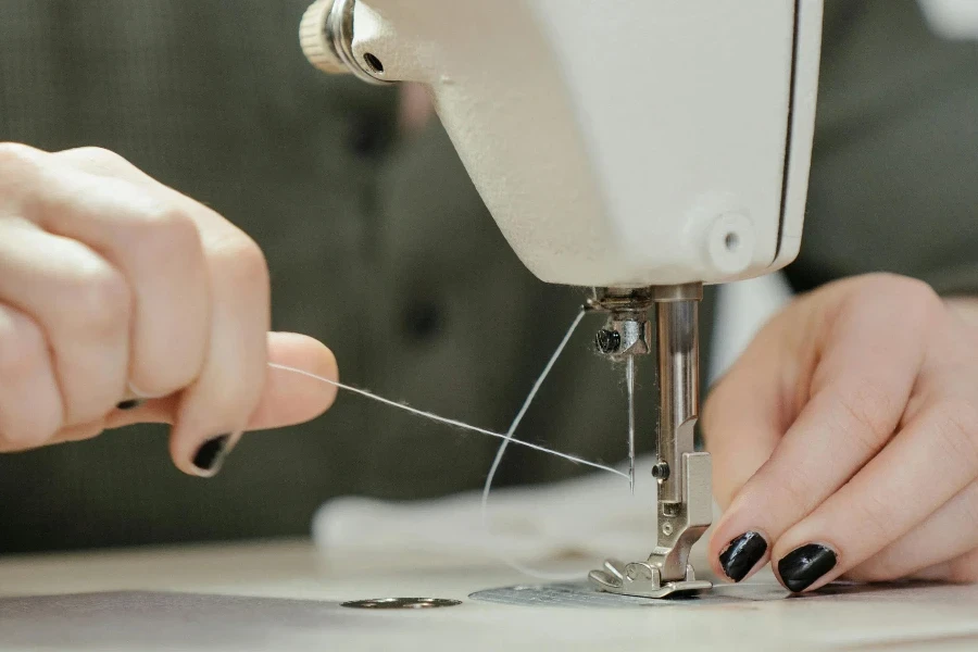 Person Sewing White Sewing Machine