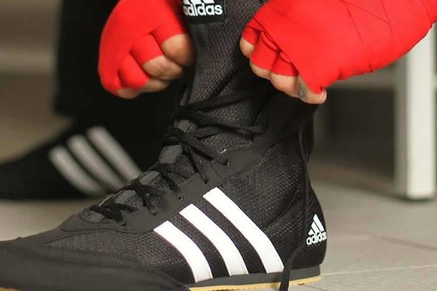 Person adjusting the laces of a boxing shoe