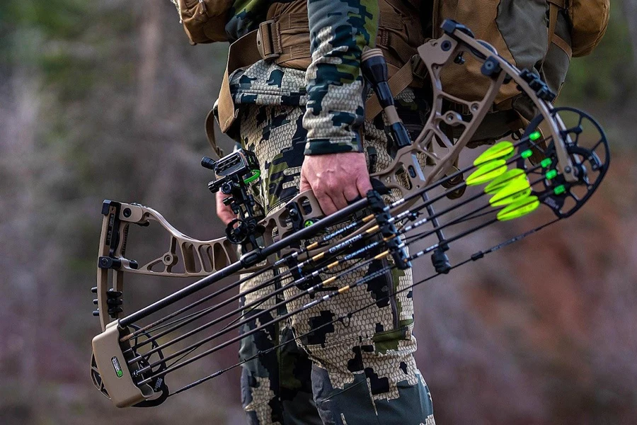 Person in camo holding a bow with a mounted quiver