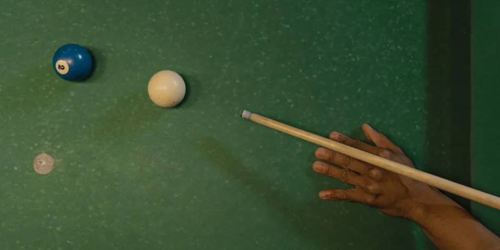 Person lining up a shot with a cue