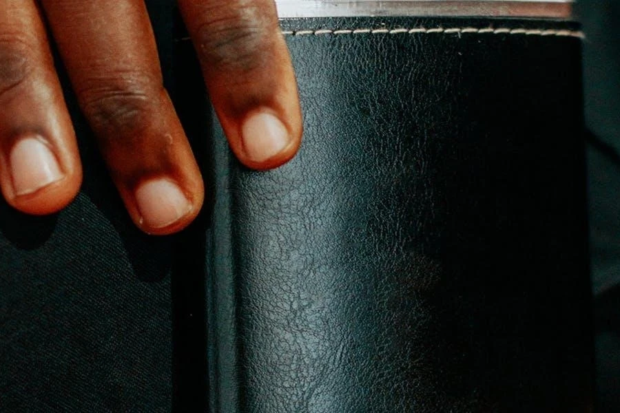 Person pulling out a leather-wrapped hip flask