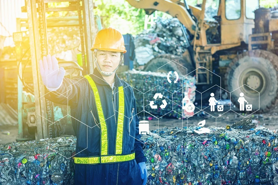 Portrait of Asian Industrial engineer workers with a pile of plastic bottles at the factory for processing and recycling