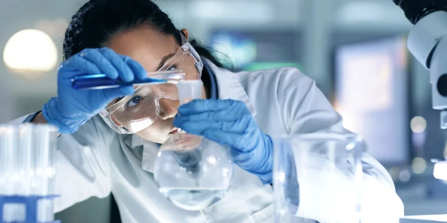 Los científicos mezclan líquido orgánico en un matraz en un laboratorio de investigación