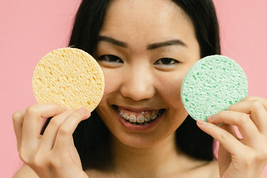 Smiling woman holding up cosmetic sponges