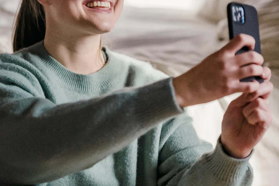 Donna sorridente che scatta un selfie con lo smartphone