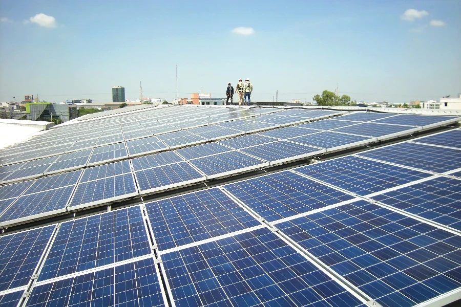 Azotea con paneles solares fotovoltaicos y trabajadores caminando