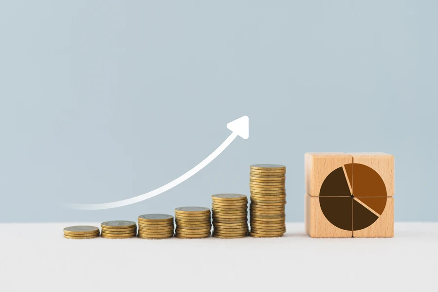 Stapel von Münzen mit ansteigender Grafik zur Darstellung der Marktdurchdringung