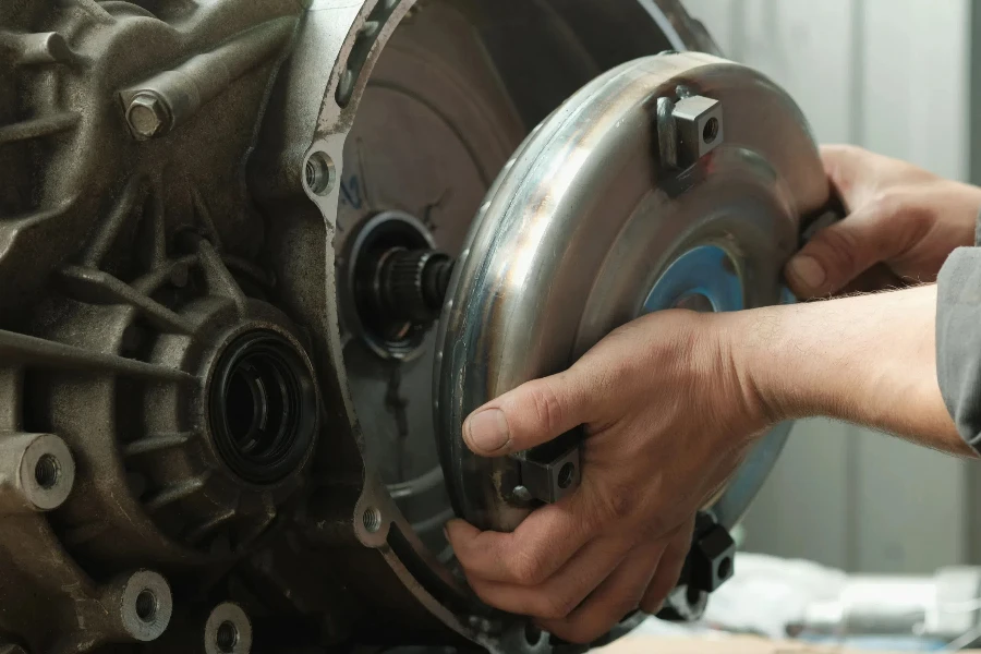 The torque converter is in the hands of an auto mechanic